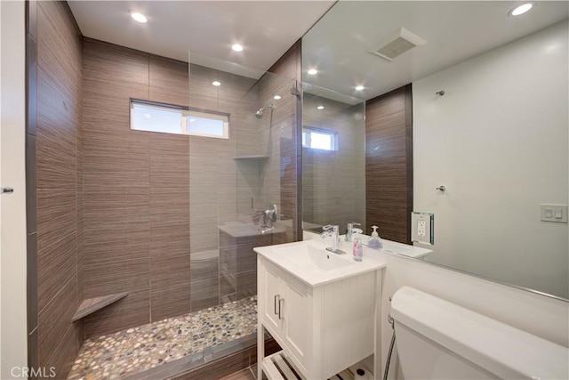 bathroom featuring visible vents, walk in shower, toilet, recessed lighting, and vanity
