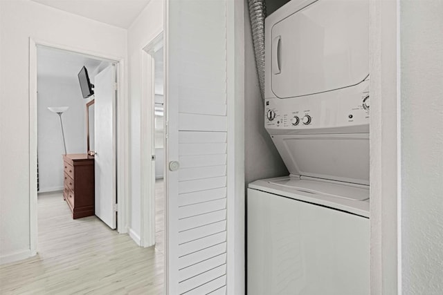 clothes washing area with stacked washer / dryer and light hardwood / wood-style floors