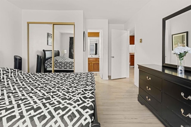 bedroom featuring ensuite bathroom, sink, a closet, and light hardwood / wood-style flooring