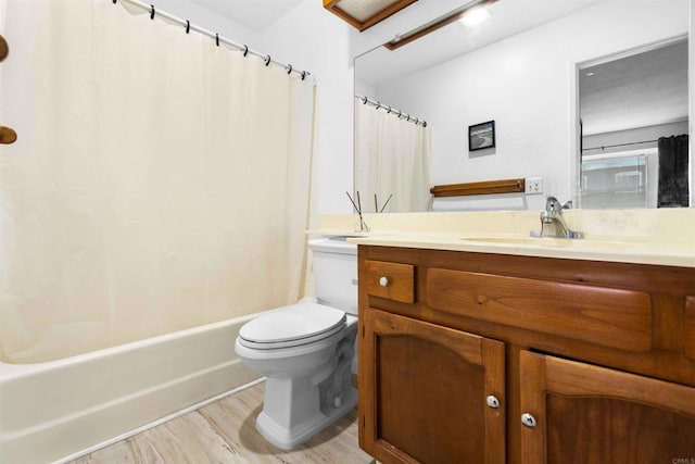 full bathroom featuring wood-type flooring, shower / tub combo, vanity, and toilet