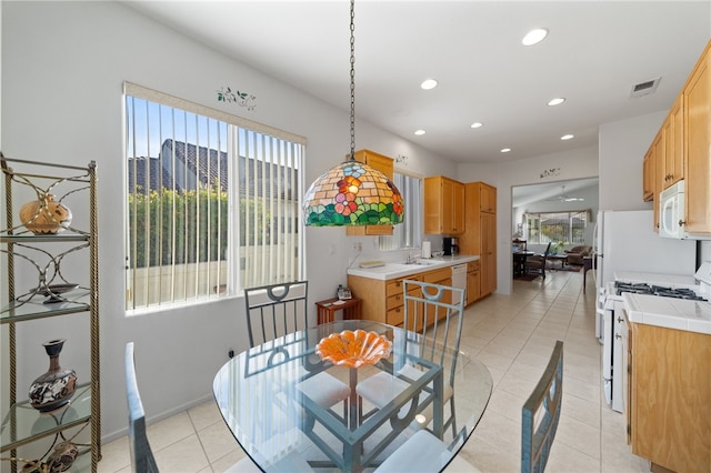 dining room featuring sink, a healthy amount of sunlight, and light tile patterned floors