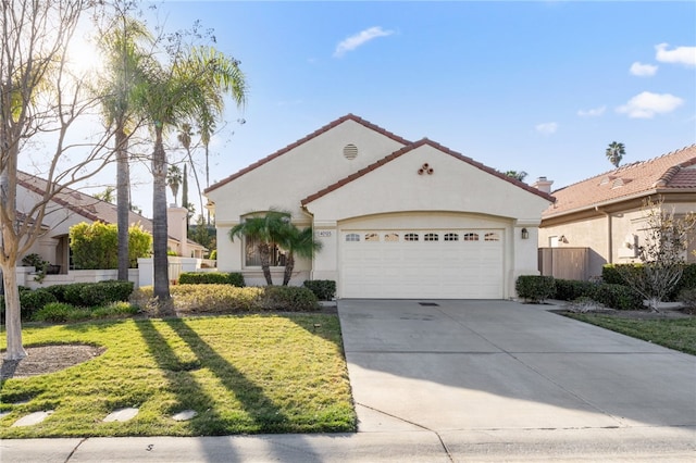 mediterranean / spanish-style house featuring a garage and a front lawn