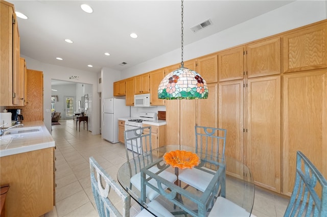 kitchen with sink, pendant lighting, white appliances, and light tile patterned floors