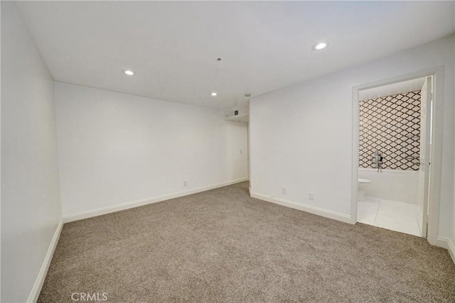 carpeted empty room featuring baseboards and recessed lighting