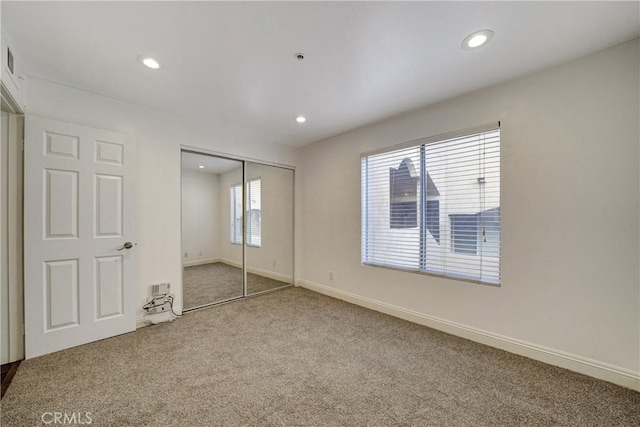 unfurnished bedroom with carpet floors, recessed lighting, a closet, and baseboards