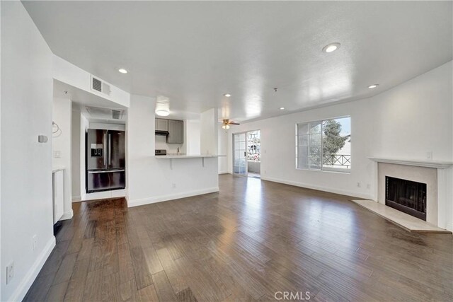 unfurnished living room with dark hardwood / wood-style floors, a premium fireplace, and ceiling fan