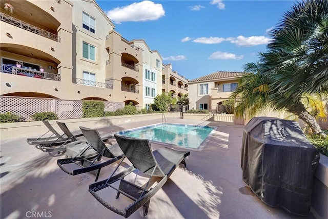 community pool featuring area for grilling, a patio area, and a residential view