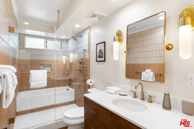 full bathroom featuring vanity, shower / bath combination with glass door, and toilet