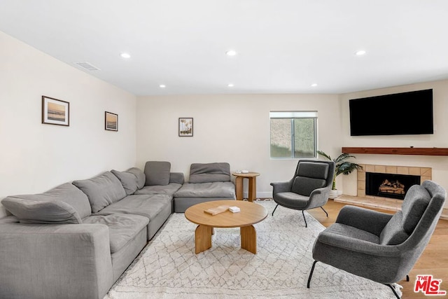 living room with light hardwood / wood-style floors and a tile fireplace