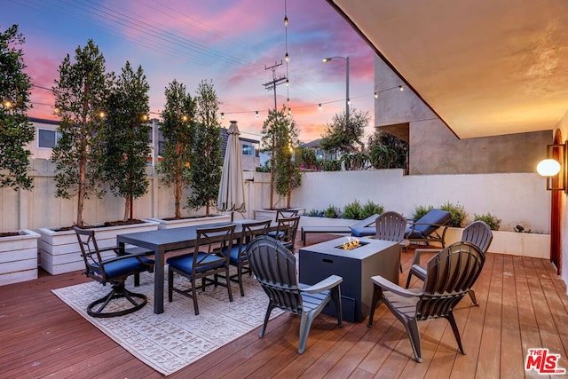 deck at dusk with a fire pit