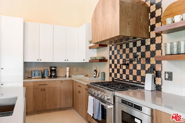 kitchen with white cabinetry, custom range hood, decorative backsplash, and gas stove