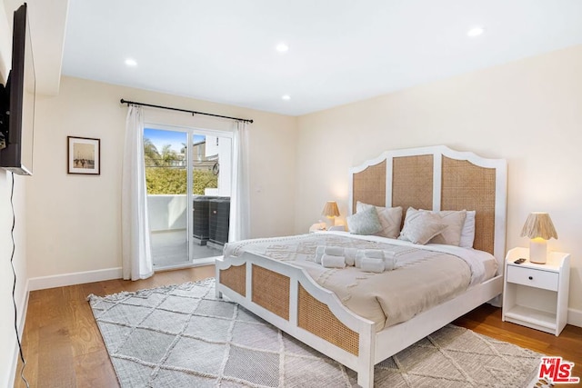 bedroom featuring access to exterior and light wood-type flooring