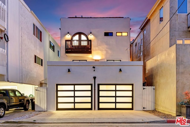 view of front of property featuring a balcony and a garage