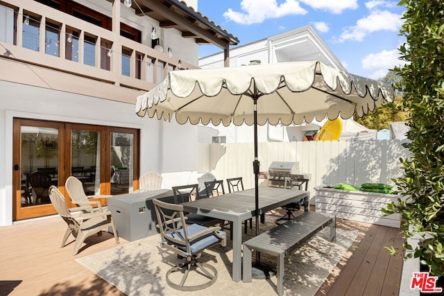 wooden terrace with a grill and french doors