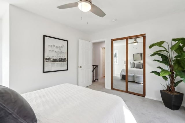 bedroom featuring ceiling fan, light carpet, and a closet