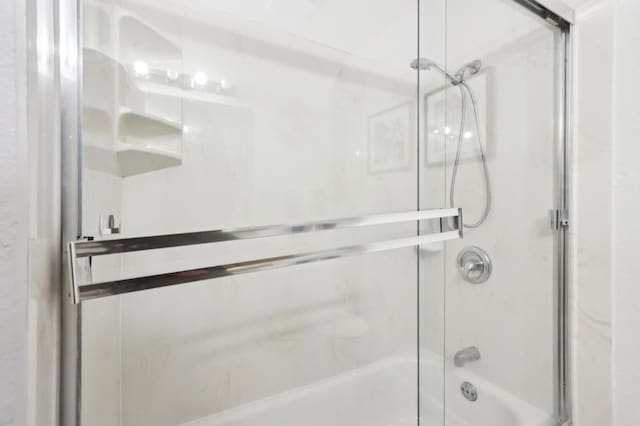 bathroom with combined bath / shower with glass door