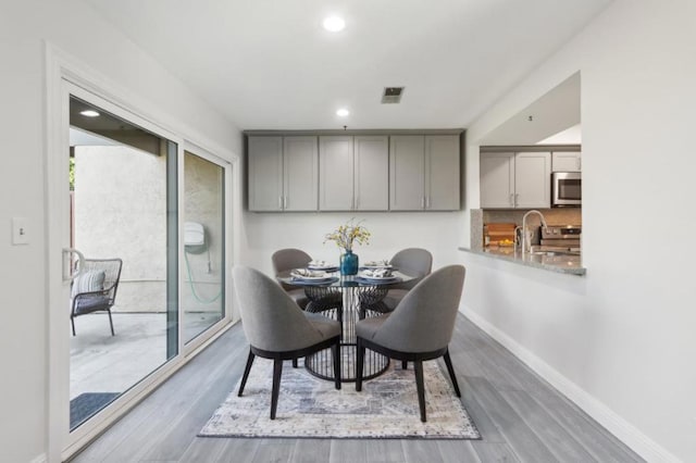 dining area featuring wood-type flooring and sink