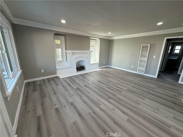 unfurnished living room featuring ornamental molding and light hardwood / wood-style flooring