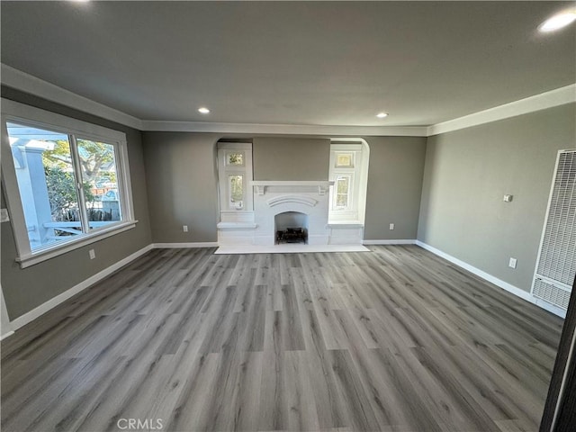 unfurnished living room featuring crown molding and light hardwood / wood-style floors