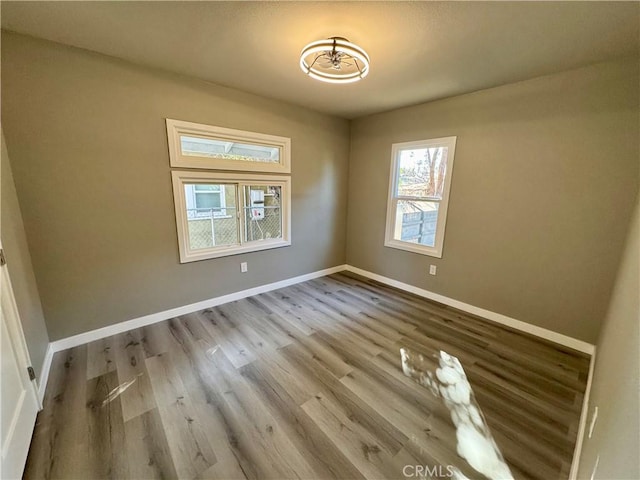 unfurnished room with hardwood / wood-style flooring