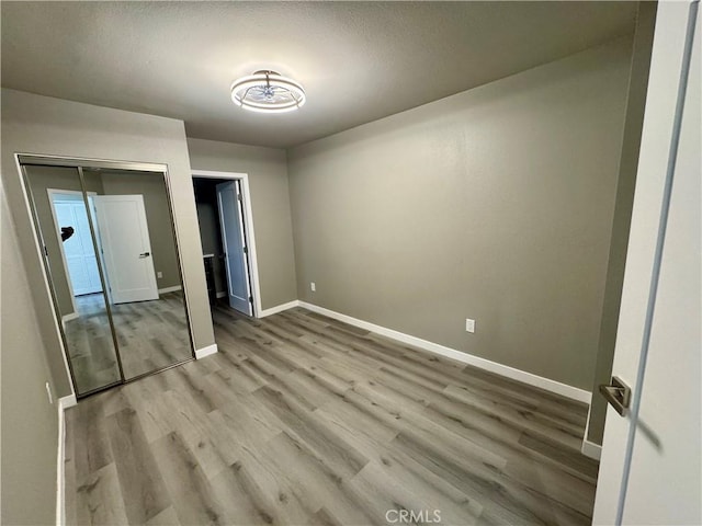 unfurnished bedroom featuring light hardwood / wood-style floors and a closet