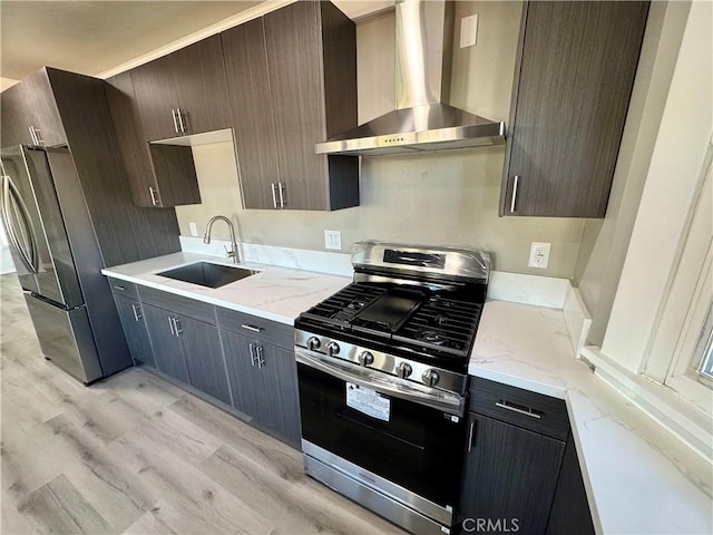 kitchen with appliances with stainless steel finishes, sink, dark brown cabinetry, light stone counters, and wall chimney exhaust hood