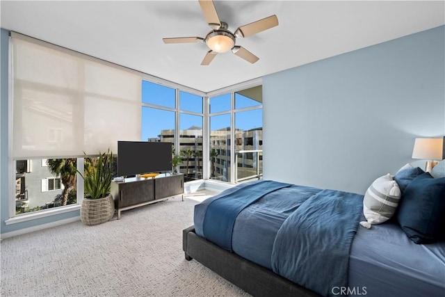 bedroom with a wall of windows, ceiling fan, and carpet