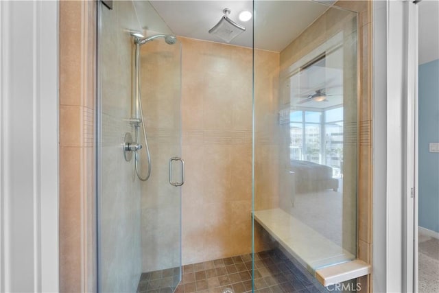 bathroom featuring ceiling fan and a shower with door