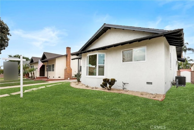 back of property with a yard and central AC unit