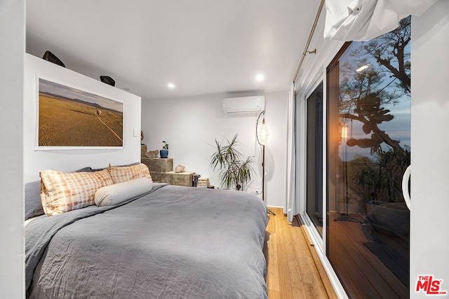 bedroom featuring a wall unit AC and light hardwood / wood-style floors