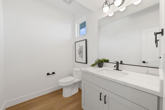 bathroom with wood-type flooring, vanity, and toilet