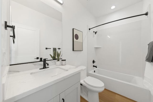 full bathroom featuring wood-type flooring, bathtub / shower combination, vanity, and toilet