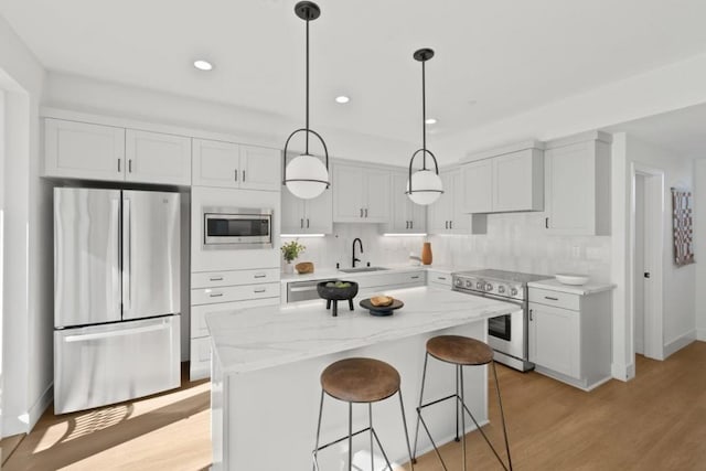 kitchen with a center island, appliances with stainless steel finishes, sink, and white cabinets