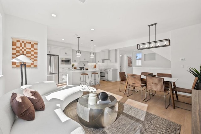 living room featuring sink and light hardwood / wood-style flooring