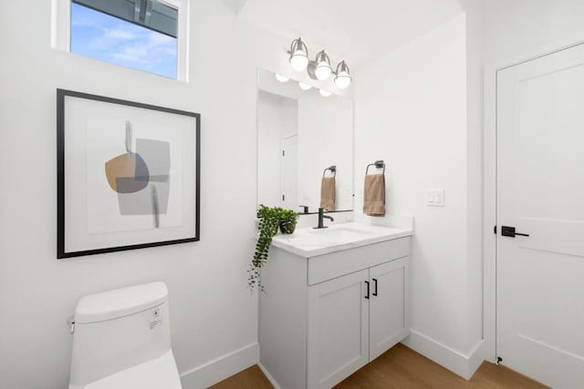 bathroom with vanity, toilet, and wood-type flooring