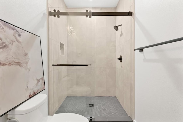 bathroom with a shower with shower door and toilet