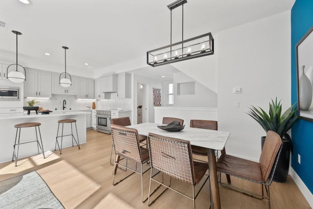 dining room featuring sink and light hardwood / wood-style floors