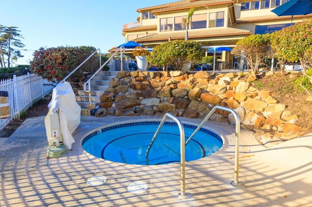 view of pool with a hot tub