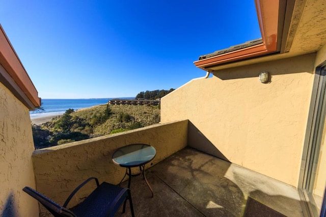 balcony featuring a beach view and a water view