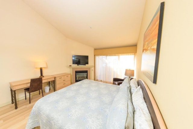 bedroom featuring lofted ceiling and light hardwood / wood-style floors