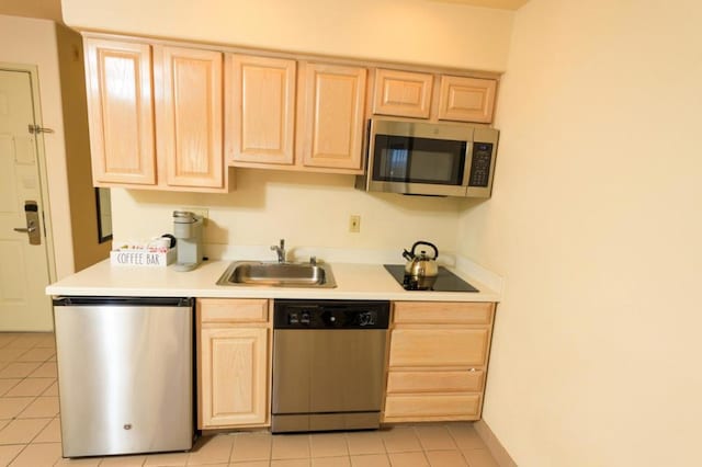 kitchen with appliances with stainless steel finishes, sink, and light brown cabinetry