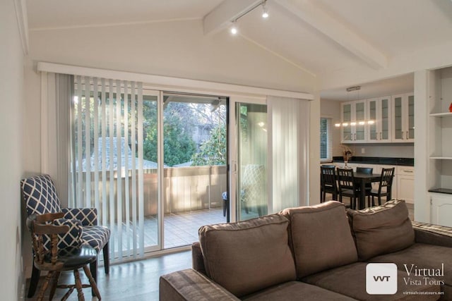 living room featuring light wood-type flooring and vaulted ceiling with beams