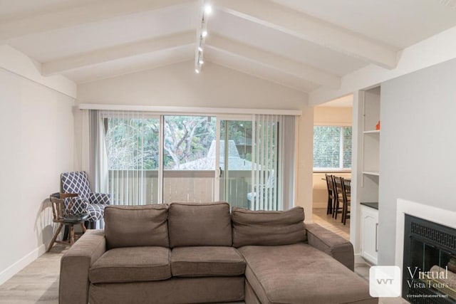 living room featuring vaulted ceiling with beams and light wood-type flooring