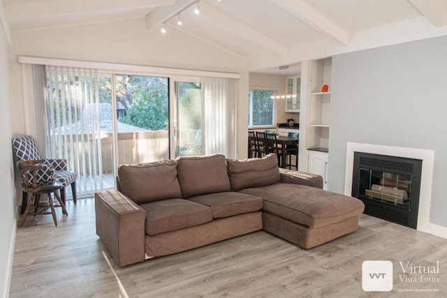 living room featuring light hardwood / wood-style flooring and vaulted ceiling with beams