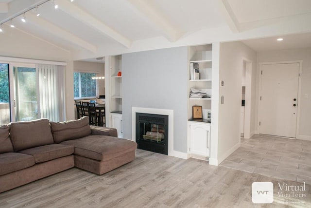 living room with beamed ceiling, built in features, and light hardwood / wood-style flooring