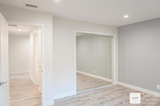 unfurnished bedroom featuring a closet and light wood-type flooring