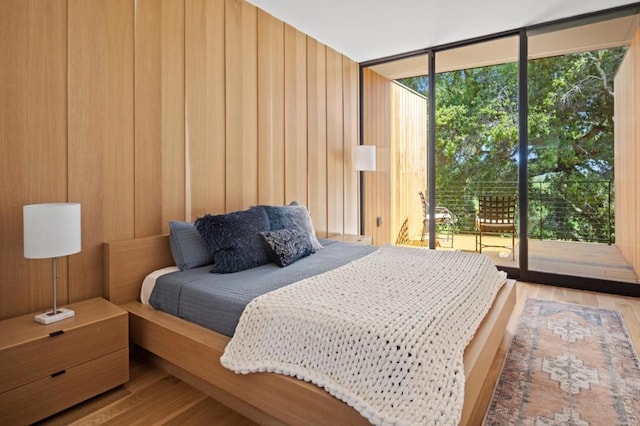 bedroom with access to exterior and wood-type flooring