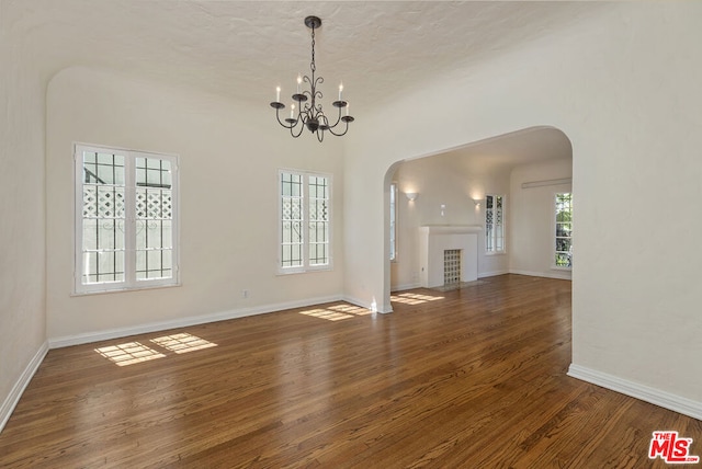 unfurnished living room with dark hardwood / wood-style floors and a notable chandelier