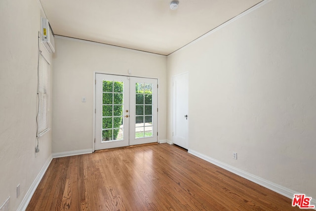 spare room featuring french doors, crown molding, and hardwood / wood-style flooring