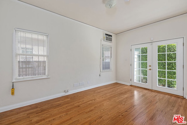 empty room featuring plenty of natural light, french doors, and light wood-type flooring